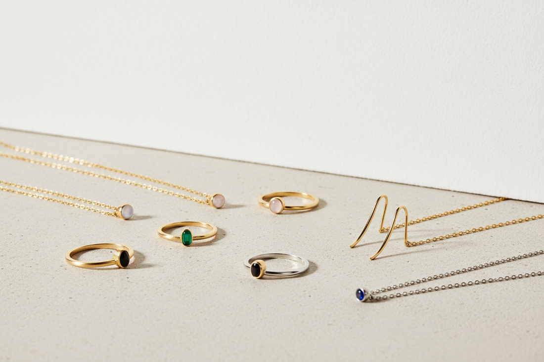 Minimal jewelry made with durable materials like gold, silver, and gemstones, styled in a clean editorial setting.