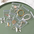 Swpeet 50Pcs 2.75"×3.93" Thick Clear PVC Jewelry Bags, Self Adhesive Portable Travel Jewelry Organizer, Plastic Jewelry Storage Bags, Transparent zipper bags, Anti Tarnish Lock Pouch for Rings - style: 7×10CM